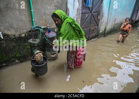 Une femme recueille de l'eau potable un tubewell, où toutes les personnes souffrent d'eau d'inondation dans un bidonville en kamalgame. Près de 2.5 lakh sont mars Banque D'Images