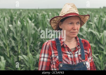 Portrait d'une agricultrice debout dans un champ de maïs, d'une travailleuse agricole dans une plantation de maïs Banque D'Images