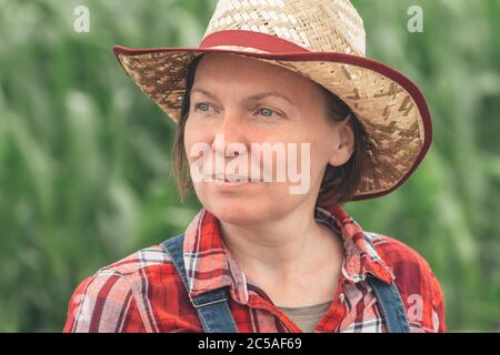 Portrait d'une agricultrice debout dans un champ de maïs, d'une travailleuse agricole dans une plantation de maïs Banque D'Images