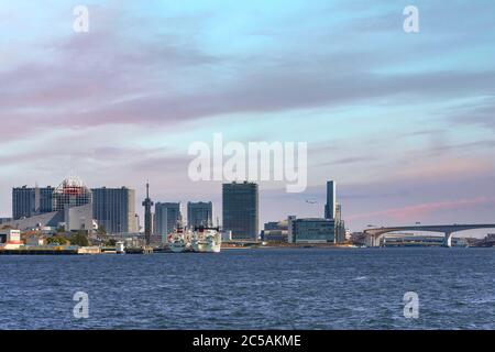 tokyo, japon - avril 04 2020 : vue sur la mer des bateaux amarrés au terminal de passagers de Harumi, dans la baie de Tokyo, devant les bâtiments de l'île Ariake au coucher du soleil. Banque D'Images