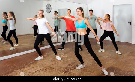 Des adolescents et des filles qui dansent la chorégraphie synchrone de groupe dans la salle de danse Banque D'Images