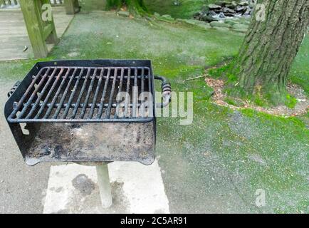 Plan horizontal d'un barbecue de zone pubienne usagé dans une aire de pique-nique avec espace de copie. Banque D'Images