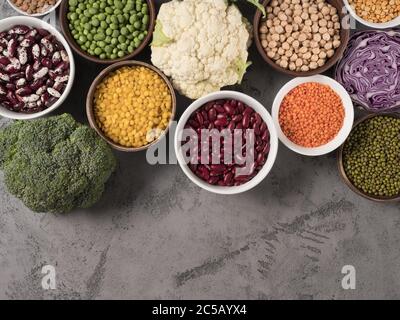 Assortiment de chou frais et différentes légumineuses sur fond gris. Banque D'Images