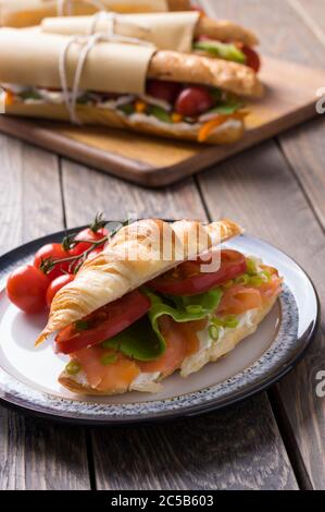 Sandwichs sous-marins frais avec diverses garnitures sur fond de bois Banque D'Images