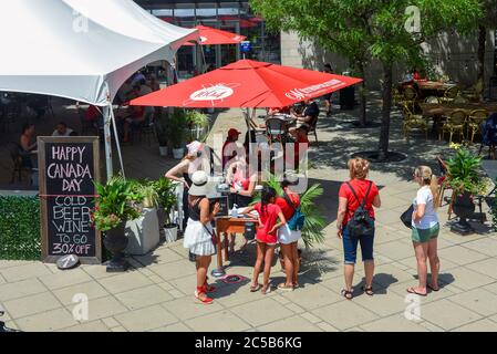 Ottawa, Canada - le 1er juillet 2020 : les célébrations de la fête du Canada étant annulées en raison de la pandémie de Covid-19, le centre-ville est moins peuplé de personnes qui ne sont autorisées à manger que sur des terrasses extérieures, comme celle-ci au Metropolitain. Une pancarte propose de la bière et du vin. Banque D'Images