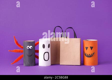 Automne saison Halloween vente concept - jouet de rouleau de toilettes tube? recyclez l'idée et le sac de papier de la boîte de shoppingpin sur fond violet, écologique Banque D'Images