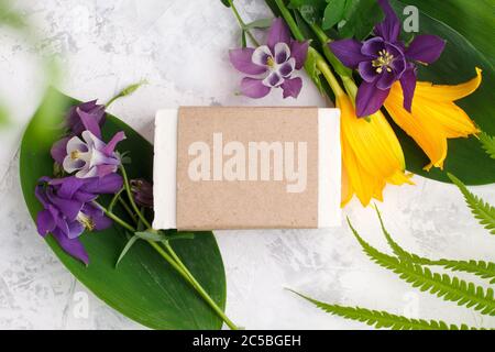 Savon solide cosmétique ou barres de shampooing produit dans l'artisanat, fleurs sur fond blanc. Concept de beauté naturelle biologique. Médecine à base de plantes, autosoins, Banque D'Images