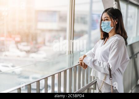 Jeune femme asiatique portant un masque médical pour la prévention de la pandémie du coronavirus (Covid-19) dans la ville. Nouveaux concepts normaux Banque D'Images