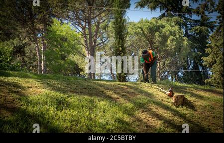 Workman se penchait en haut de la colline dans la veste orange à Bologne, Italie Banque D'Images