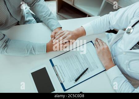 Le médecin a serré les mains et consolé les patients qui s'inquiétaient du traitement. Banque D'Images