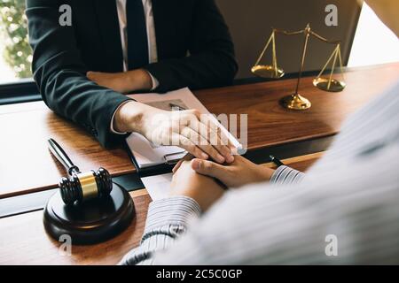 L'avocat et le tribunal utilisent leurs mains pour console le client qui sait qu'il ne gagnera pas l'affaire. Banque D'Images
