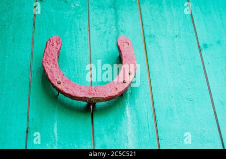 Vieux fer à cheval sur un mur en bois rouge Banque D'Images