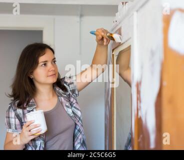 Jeune femme peint penderie et fait des réparations dans l'appartement Banque D'Images