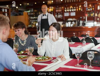 Les femmes d'affaires avec l'homme partenaire ayant le dîner et boire du vin au restaurant Banque D'Images