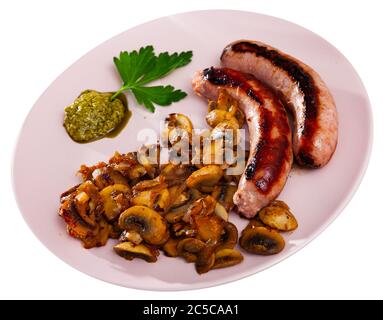 Saucisses grillées épicées garnies de champignons rôtis. Isolé sur fond blanc Banque D'Images