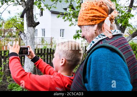 Grand-mère et petit-fils heureux prenant photo selfie. Concept de famille heureuse, appel vidéo Banque D'Images