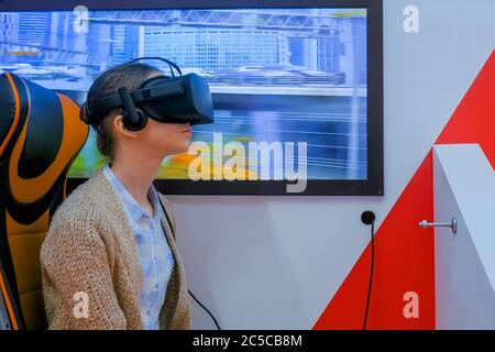 MOSCOU, RUSSIE - 25 JUIN 2019 : VR EXPO. Femme utilisant un casque noir de réalité virtuelle, regardant autour et jouant dans les transports publics Banque D'Images