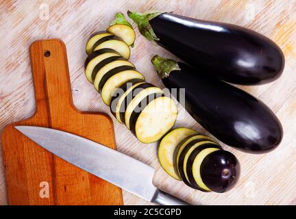 Aubergines biologiques hachées sur fond de bois. Concept de cuisine végétarienne Banque D'Images