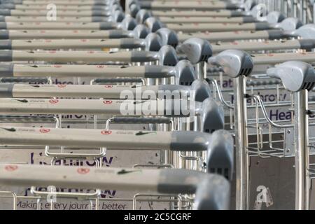 Gros plan des chariots à bagages empilés à l'extérieur du terminal Queens, aéroport de Heathrow, Londres, Royaume-Uni Banque D'Images