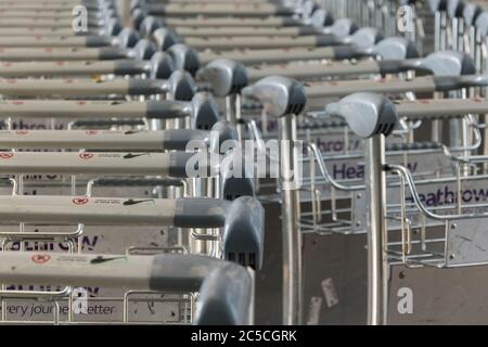 Gros plan des chariots à bagages empilés à l'extérieur du terminal Queens, aéroport de Heathrow, Londres, Royaume-Uni Banque D'Images