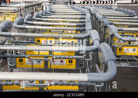 Gros plan des chariots à bagages empilés à l'extérieur du terminal Queens, aéroport de Heathrow, Londres, Royaume-Uni Banque D'Images