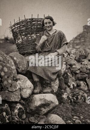 Une vue du début des années 1920 d'une femme irlandaise avec son panier de crème, à Killarney, comté de Kerry. Contrairement à d'autres formes de panier tissé, la crème a été faite à l'envers, le saule solide et flexible étant plié en place, créant un panier robuste, mais élégant qui était souvent utilisé pour transporter le gazon. Initialement photographié par Clifton Adams (1890-1934) pour 'Ireland: The Rock Wharce I was hewn', un reportage du magazine National Geographic de mars 1927. Banque D'Images