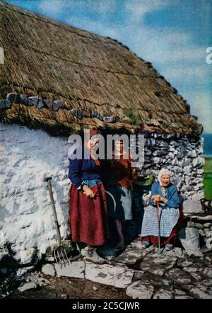 Un portrait autochrome du début des années 1920 de trois générations de femmes d'une famille Connemara à l'extérieur de leur maison de campagne au toit de chaume dans le comté de Galway. Initialement photographié par Clifton Adams (1890-1934) pour 'Ireland: The Rock Wharce I was hewn', un reportage du magazine National Geographic de mars 1927 Banque D'Images