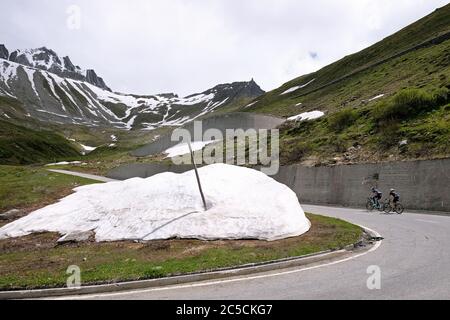 Cycliste sur le col de Nufenen dans les Alpes suisses, qui relie les cantons du Valais et du Tessin, Suisse. Banque D'Images