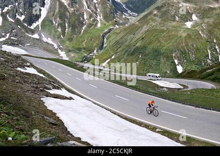 Cycliste sur le col de Nufenen dans les Alpes suisses, qui relie les cantons du Valais et du Tessin, Suisse. Banque D'Images