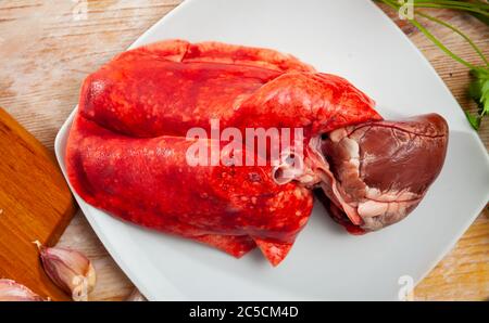 Cœur d'agneau frais et poumons sur planche à découper en bois avec assaisonnements. Cuisine maison Banque D'Images