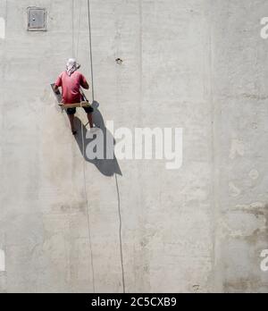 Le maître répare le mur. Pose du plâtre sur le mur. Les constructeurs masculins au travail. Contexte sur le thème de la construction. Banque D'Images