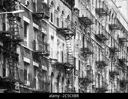 Photo en noir et blanc des anciens bâtiments résidentiels de Manhattan avec des évasions de feu, New York City, États-Unis. Banque D'Images