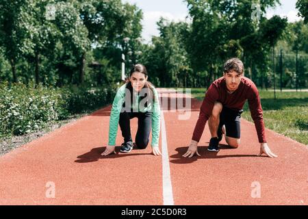 Couple en position de départ sur la piste de course en position de stationnement Banque D'Images