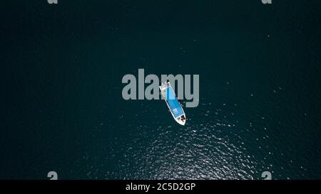 un bateau avec 2 en moteurs attendant au milieu de la mer avec des gens dessus Banque D'Images