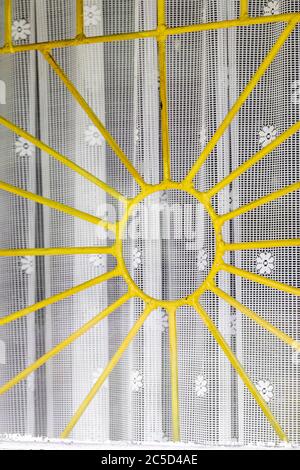 Très vieux grilles de fenêtre jaune en métal avec arrière-plan de rideaux blancs avec espace de copie Banque D'Images