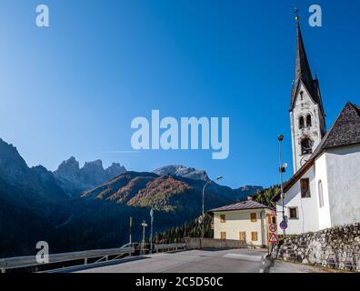 Scène des Dolomites alpins d'automne, Sudtirol, Italie. Village paisible et vieille église vue de la route, Falcade Alto, Belluno. Banque D'Images