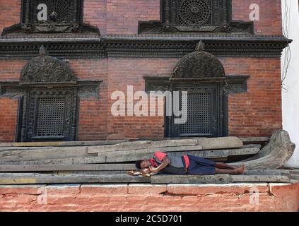 Katmandou, Népal. 2 juillet 2020. Un ouvrier prend une sieste sous la maison Kumari à la place Hanumanchoka Durbar à Katmandou, capitale du Népal, le 2 juillet 2020. Les ouvriers ont été directement touchés par moins de travaux après la facilité d'environ 3 mois de confinement récité du gouvernement dans le contexte de l'épidémie de COVID-19. Crédit : Sunil Sharma/ZUMA Wire/Alay Live News Banque D'Images