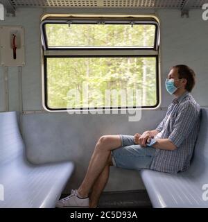 L'homme triste porte un masque protecteur dans le train pour protéger le système respiratoire contre l'infection à coronavirus, Covid-19. Mesure préventive. Nouvelle normale. Banque D'Images