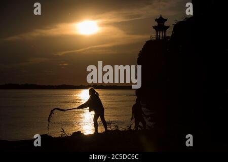 Harbin, province chinoise de Heilongjiang. 12 juin 2020. Wang Linyao, une fille de 11 ans, joue sur la rive d'une rivière au village de Yuye, dans le canton de Jiejinkou Hezhe, dans la ville de Tongjiang, dans la province de Heilongjiang, au nord-est de la Chine, le 12 juin 2020. Le peuple Hezhe, l'un des plus petits groupes ethniques minoritaires en Chine qui vivaient autrefois de la pêche et de la chasse, est maintenant en train d'embrasser la prospérité à mesure qu'il développe diverses industries tout en préservant sa culture et son patrimoine. Crédit: Zhang Tao/Xinhua/Alay Live News Banque D'Images