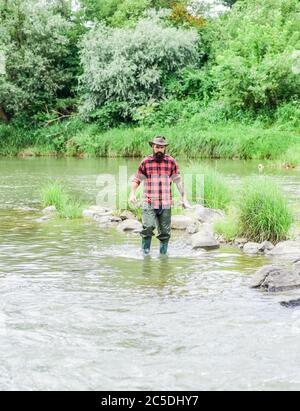 Nous avons mis en place vos besoins. Week-end d'été. Pêche à la mouche réussie. Technique de pêche de spectacle de pêcheur utiliser la tige. Activité de loisir et de sport. Pêcheur barbu dans l'eau. Homme mature pêche à la mouche. Homme attrapant le poisson. Banque D'Images