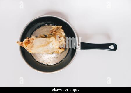 Soupe d'os de bœuf ragoût dans une casserole isolée sur fond blanc. Banque D'Images