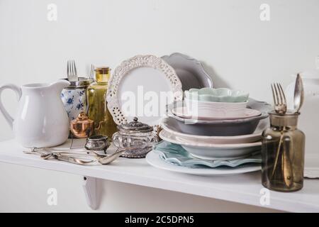 Acheter de la vaisselle ancienne vintage romantique dans le concept de magasin secondaire. Pile de vaisselle ancienne sur l'étagère du magasin pour la cuisine. Banque D'Images