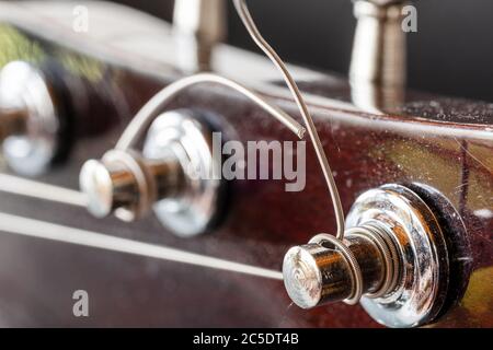 Touches mécaniques pour régler la guitare. Cordes métalliques UNE guitare acoustique réglée. Leçons de guitare. Détails chromés de l'instrument de musique. Banque D'Images