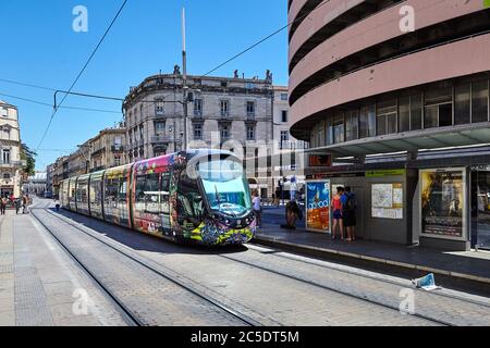 MONTPELLIER, FRANCE - 24 juin 2015 : transports publics urbains sur la rue. Magnifique tramway multicolore. Passagers à un arrêt de tramway Banque D'Images