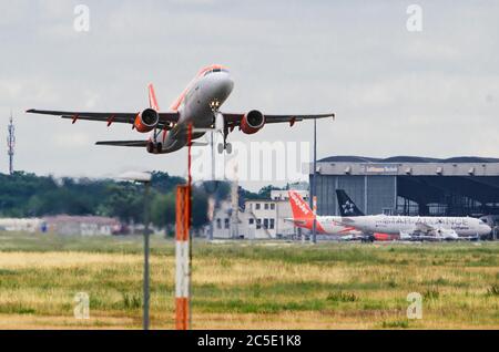 02 juillet 2020, Brandebourg, Schönefeld: Un Airbus A320-200 de la compagnie aérienne easyJet Europe dévolera de la piste de l'aéroport Berlin-Schönefeld pour son vol vers Corfou. En arrière-plan, deux avions easyJet et Star Alliance se trouvent devant le hangar de Lufthansa Technik. Photo: Soeren Stache/dpa-Zentralbild/dpa Banque D'Images