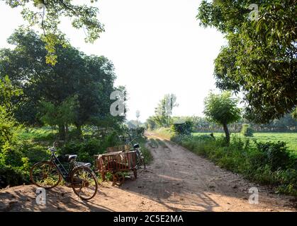 Vélo et chariot vides sur la route de campagne à Inwa, ou Ava, Mandalay, Myanmar, Asie du Sud-est. Paysage rural sans personne. Banque D'Images