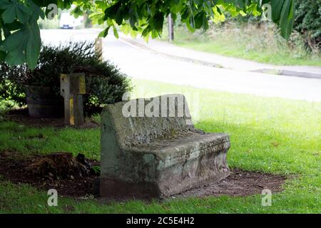 Un ancien banc de pierre dans le village de Old Milverton, Warwickshire, Angleterre, Royaume-Uni Banque D'Images