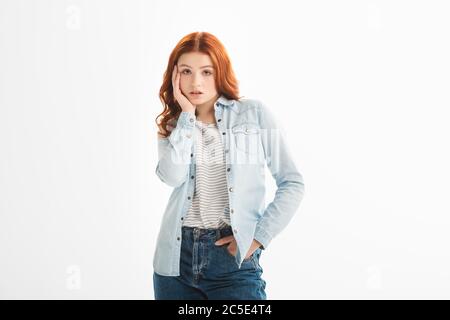 belle fille de redhead très bien réfléchie en vêtements denim, isolée sur blanc Banque D'Images