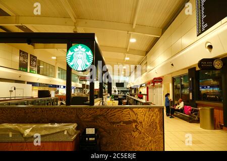 2 juillet 2020, aéroport de Luton, Royaume-Uni : les passagers sont assis à côté d'un café Starbucks fermé en route vers les salons de départ de l'aéroport de Luton. Le nombre de vols entre le Royaume-Uni et certains pays européens commence à augmenter et les gouvernements devraient bientôt annoncer des ponts aériens entre les pays pour faciliter les voyages et le tourisme. L'impact économique du virus sur le commerce de détail et d'autres secteurs a été sévère et de nombreuses entreprises sont encore fermées malgré l'assouplissement des restrictions. Banque D'Images