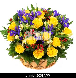 Roses jaunes naturelles et iris bleus dans un panier isolé sur fond blanc Banque D'Images